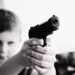 Imagem Reprodução - Criança com arma de fogo