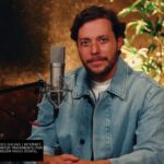 André Valadão em estúdio diante de um microfone durante a gravação do álbum Versões Acústicas, Volume 3