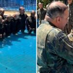 Recrutas da Força Aérea Brasileira orando em uma piscina durante cerimônia de batismo na Base Aérea de Brasília