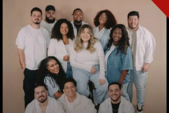 Integrantes do grupo Get Worship reunidos para uma foto oficial, sorrindo, vestindo roupas claras.