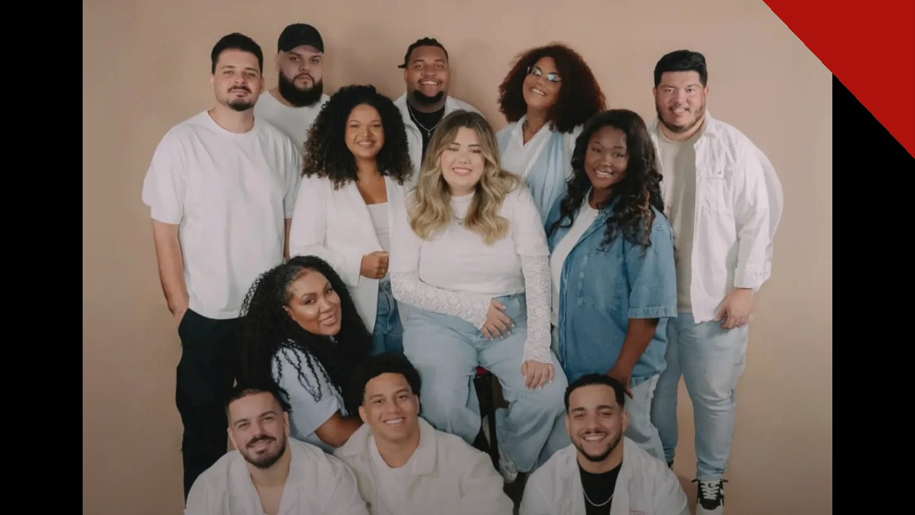 Integrantes do grupo Get Worship reunidos para uma foto oficial, sorrindo, vestindo roupas claras.