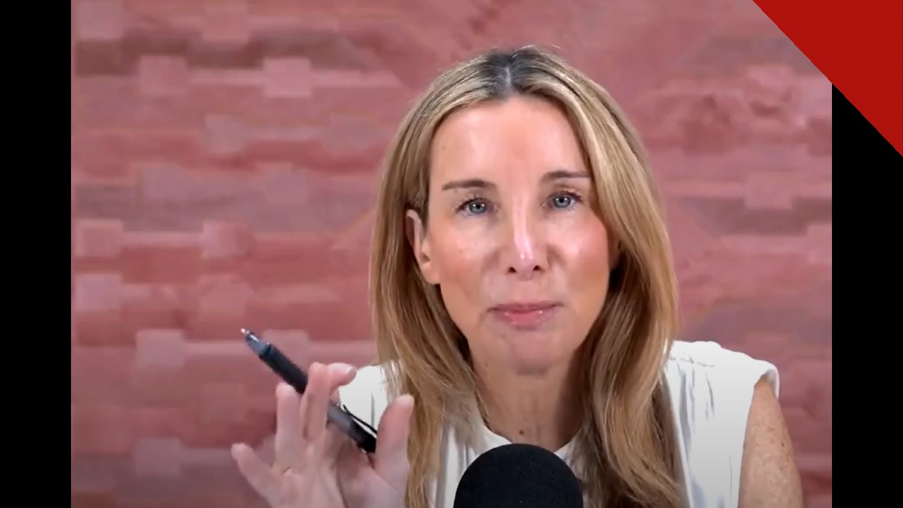 A podcaster Jennifer Welch falando durante a gravação do programa I've Had It, segurando uma caneta diante do microfone