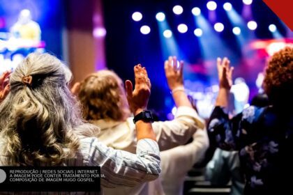 Fiéis de igreja com as mãos levantadas em adoração sob luzes coloridas durante um momento de oração