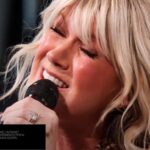 Cantora Natalie Grant cantando com os olhos fechados em apresentação ao vivo