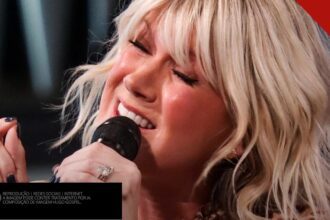 Cantora Natalie Grant cantando com os olhos fechados em apresentação ao vivo