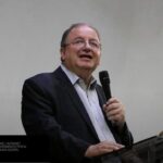 Reverendo Arival Dias Casimiro pregando com microfone em púlpito; composição de imagem Hugo Gospel