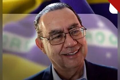 Augusto Cury pede votos para Flávio Bolsonaro: o escritor sorrindo em foto de divulgação, com a bandeira do Brasil ao fundo