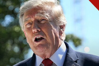Trump terá de depor no processo contra a BBC: presidente Donald Trump falando ao ar livre, de terno escuro e gravata vermelha