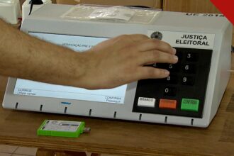 CNBB pede voto consciente no segundo turno: mão de eleitor digitando em urna eletrônica da Justiça Eleitoral