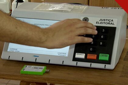 CNBB pede voto consciente no segundo turno: mão de eleitor digitando em urna eletrônica da Justiça Eleitoral