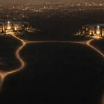 As igrejas multisite somam 1800 nos EUA: vista aérea noturna de campi de igrejas ligados por estradas iluminadas, imagem do estudo Multisite Revealed