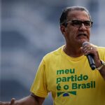 Malafaia alerta contra paixão política: pastor Silas Malafaia falando ao microfone em ato público, de camiseta amarela