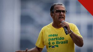 Malafaia alerta contra paixão política: pastor Silas Malafaia falando ao microfone em ato público, de camiseta amarela