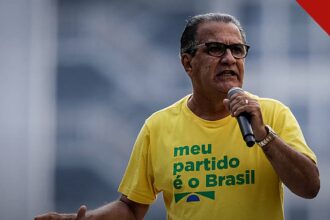 Malafaia alerta contra paixão política: pastor Silas Malafaia falando ao microfone em ato público, de camiseta amarela
