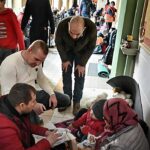 Os bispos pedem manutenção do TPS: refugiados ucranianos recebendo ajuda perto da fronteira com a Polônia