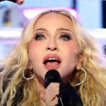 A Madonna declara apoio a Lula: a cantora em apresentação com microfone na mão e o braço levantado