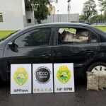 As apreensões de maconha crescem no Paraná: carro com pacotes apreendidos ao lado de placas do BPFron, da FICCO e do 14º BPM