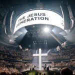 Forrest Frank anuncia documentário: arena lotada da Jesus Generation Tour com a cruz iluminada no palco e o telão da turnê