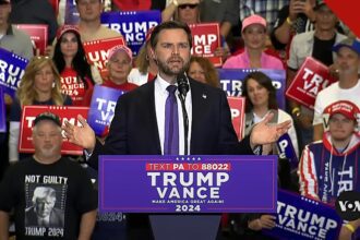 Vice-presidente JD Vance discursa em comício com apoiadores ao fundo, em imagem que ilustra o ato em que Vance lidera oração do Pai Nosso