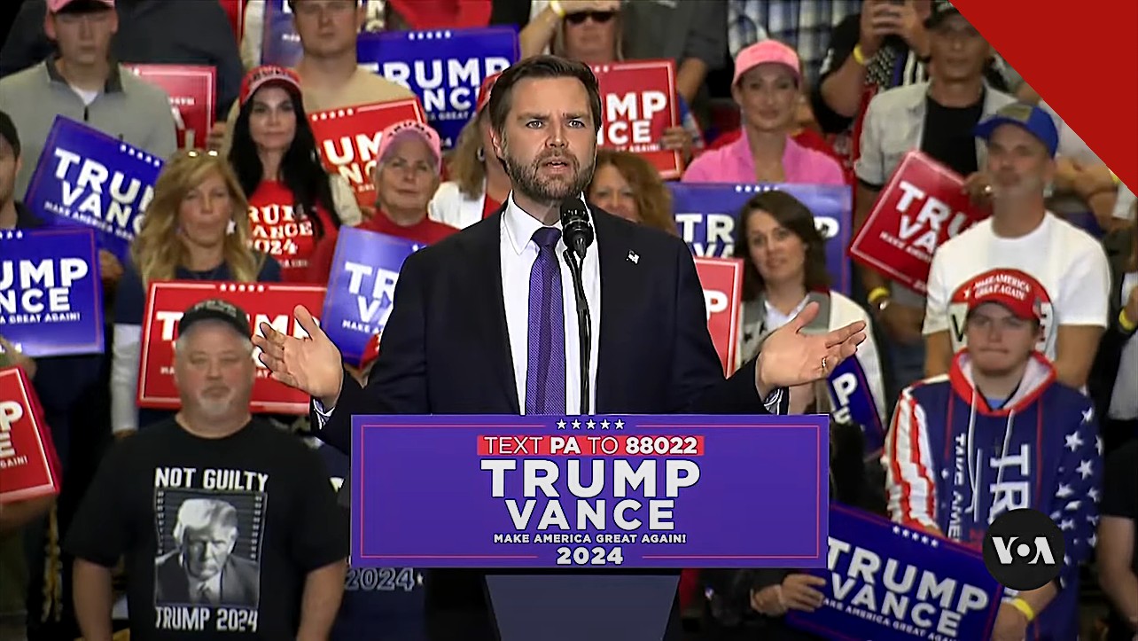 Vice-presidente JD Vance discursa em comício com apoiadores ao fundo, em imagem que ilustra o ato em que Vance lidera oração do Pai Nosso