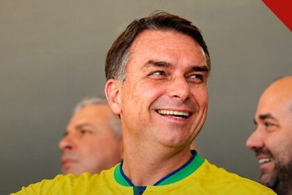 Flávio Bolsonaro sorrindo com a camisa da seleção brasileira, em imagem que ilustra o dia em que Flávio Bolsonaro faz ato em Belo Horizonte