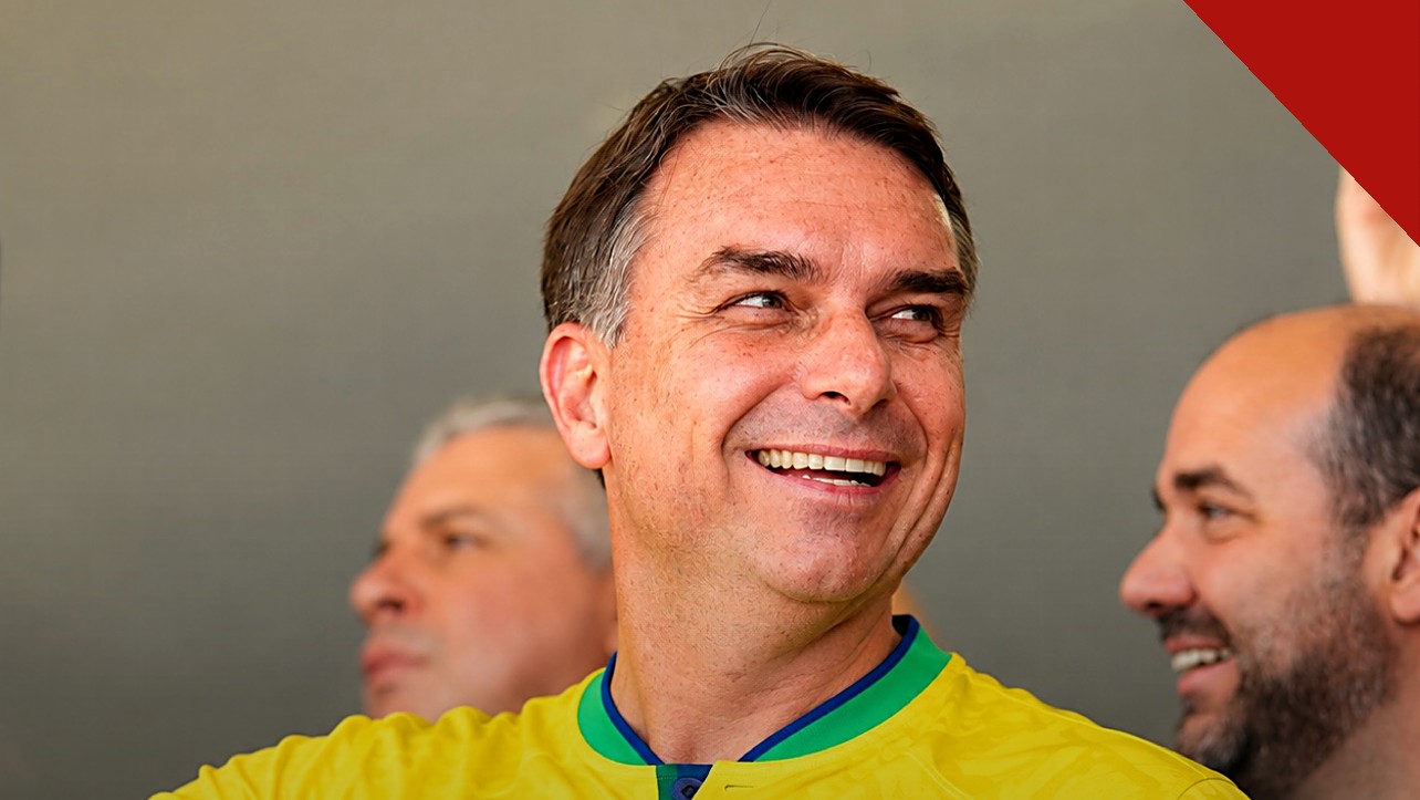 Flávio Bolsonaro sorrindo com a camisa da seleção brasileira, em imagem que ilustra o dia em que Flávio Bolsonaro faz ato em Belo Horizonte
