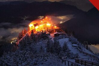 incêndio no Ninho da Águia de Hitler: o edifício do Kehlsteinhaus em chamas durante a noite, no topo nevado da montanha nos Alpes da Baviera