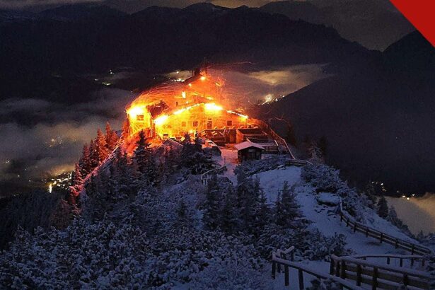 incêndio no Ninho da Águia de Hitler: o edifício do Kehlsteinhaus em chamas durante a noite, no topo nevado da montanha nos Alpes da Baviera