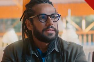 Amaury Lorenzo revela avanço da surdez: o ator como Lucas, personagem da novela Por Você, de dreadlocks e óculos em cena da trama da Globo