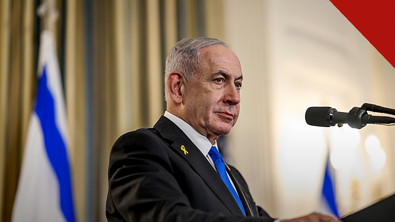 Netanyahu alerta o Irã: Benjamin Netanyahu falando ao microfone em coletiva de imprensa, com a bandeira de Israel ao fundo