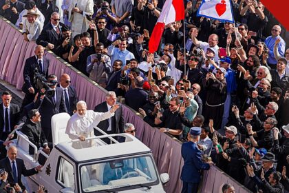 amor ao próximo segundo o Papa: Papa Leão XIV acenando aos fiéis no papamóvel, cercado pela multidão no Vaticano