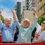 Lula descarta imprensa na comunicação: presidente Lula de braços erguidos ao lado de Janja em ato em São Paulo durante a campanha de 2026