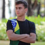 Nikolas não reconhece vitória de Lula: deputado Nikolas Ferreira de braços cruzados com a faixa do Brasil no ombro