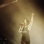Jessie J mostra recuperação após cirurgia: a cantora Jessie J cantando em show em Londres, com o braço levantado