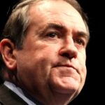 Huckabee fala de Tucker Carlson: retrato do embaixador dos Estados Unidos em Israel, Mike Huckabee, de terno e gravata