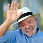 risco-país dispara 26% após reeleição de Lula: presidente sorrindo e acenando, de camisa azul e chapéu claro
