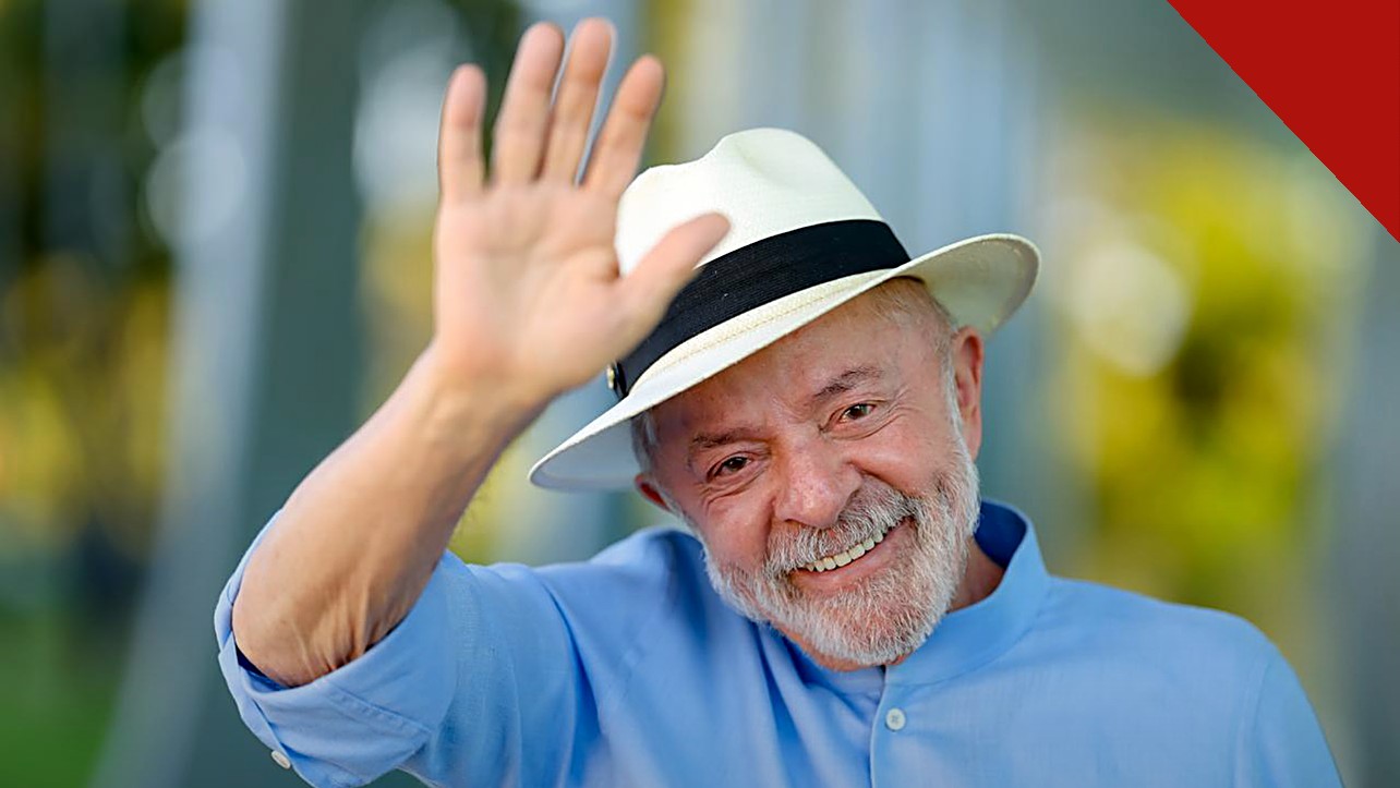 risco-país dispara 26% após reeleição de Lula: presidente sorrindo e acenando, de camisa azul e chapéu claro