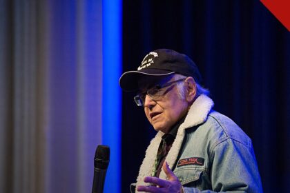 Walter Koenig morre aos 90 anos: ator de boné e jaqueta falando ao microfone em evento com fãs