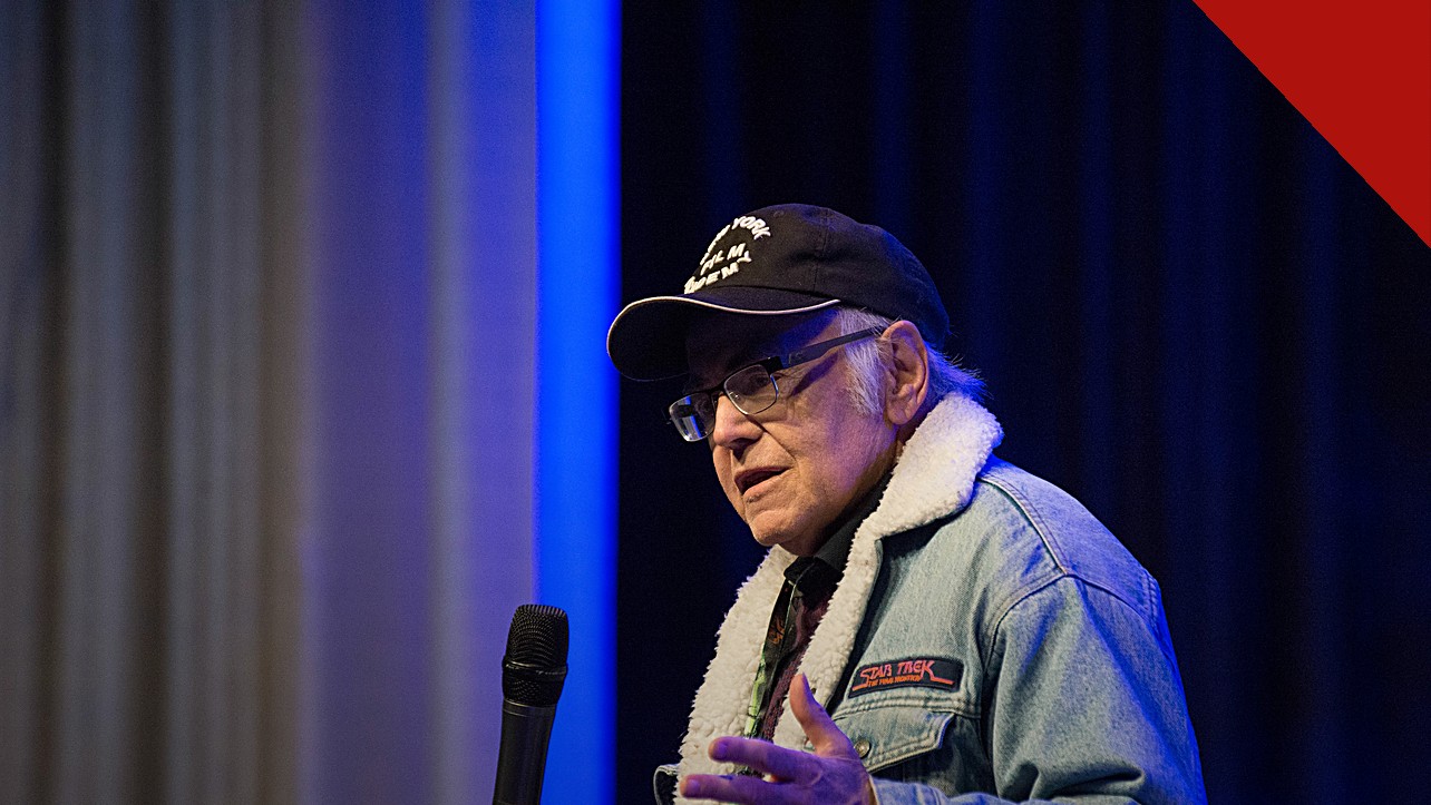Walter Koenig morre aos 90 anos: ator de boné e jaqueta falando ao microfone em evento com fãs