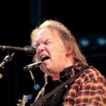 Neil Young processa Trump por uso de música: o cantor Neil Young em show, com violão e gaita