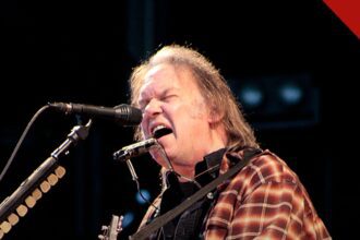 Neil Young processa Trump por uso de música: o cantor Neil Young em show, com violão e gaita