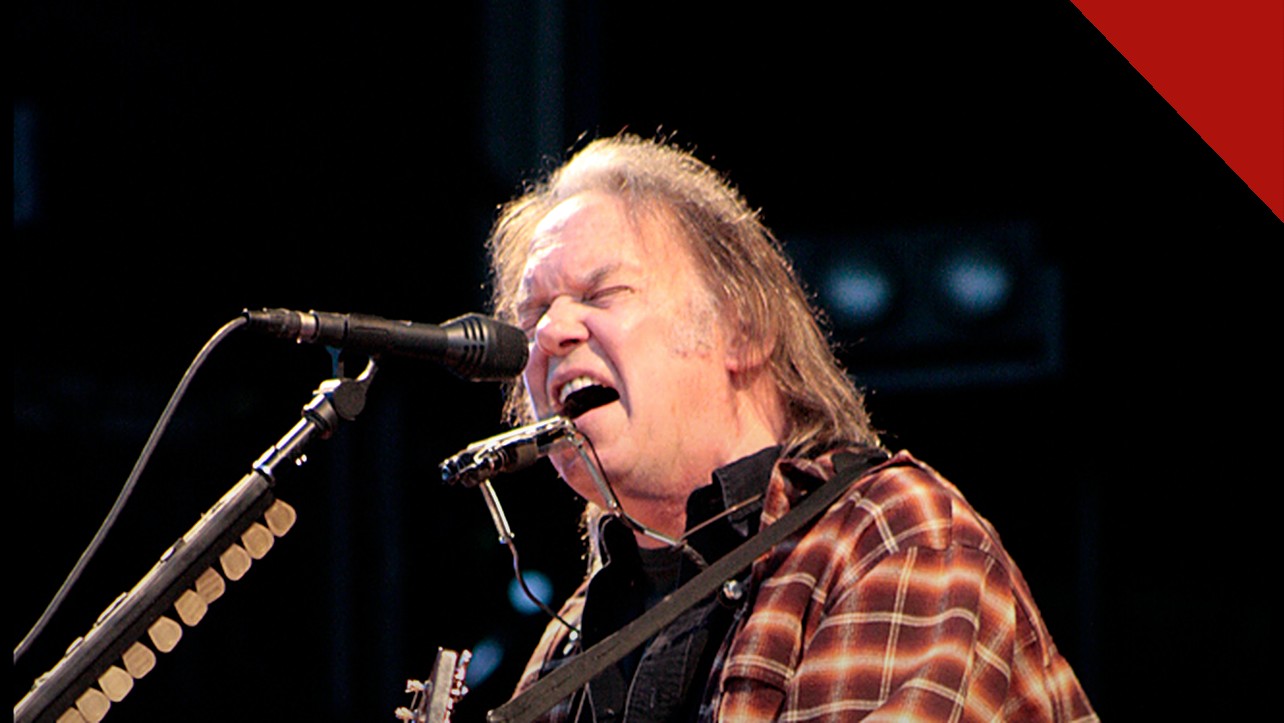 Neil Young processa Trump por uso de música: o cantor Neil Young em show, com violão e gaita