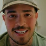 Jottapê explica desistência de A Fazenda é o tema de Jottapê sorrindo de boné em vídeo publicado nas redes sociais