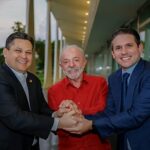 Lula articula permanência de Motta e Alcolumbre no comando do Congresso, com Lula de mãos dadas com Davi Alcolumbre e Hugo Motta no Palácio da Alvorada