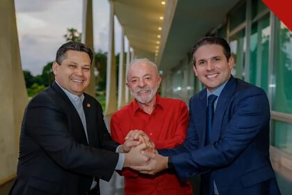 Lula articula permanência de Motta e Alcolumbre no comando do Congresso, com Lula de mãos dadas com Davi Alcolumbre e Hugo Motta no Palácio da Alvorada