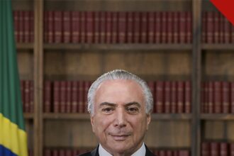 Temer reconhece vitória de Lula é o gesto de Michel Temer, e a imagem mostra o ex presidente em retrato oficial com a bandeira do Brasil ao fundo