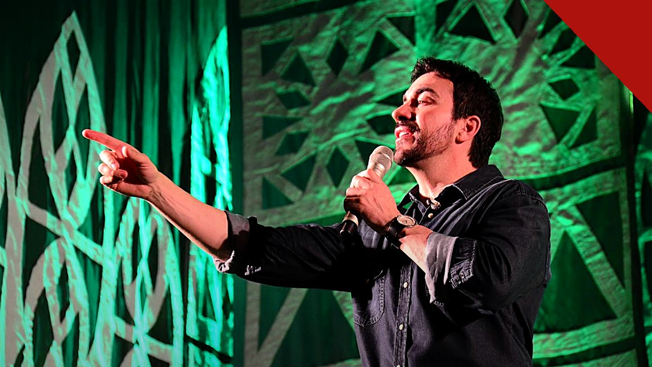 relato de Padre Fábio de Melo volta a repercutir nas redes sociais, e a imagem mostra o Padre Fábio de Melo cantando e apontando em show com luz verde