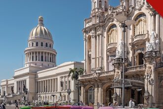 pastor é liberto após meses preso em Cuba por protestar contra apagões, e a imagem mostra o Capitólio de Havana e carros clássicos em rua da capital de Cuba