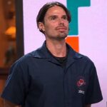 Jônatas Faro explica desistência de A Fazenda 18 no reality da Record, e a imagem mostra o ator Jônatas Faro com o uniforme do programa A Fazenda, de camisa azul com o nome bordado