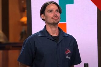 Jônatas Faro explica desistência de A Fazenda 18 no reality da Record, e a imagem mostra o ator Jônatas Faro com o uniforme do programa A Fazenda, de camisa azul com o nome bordado